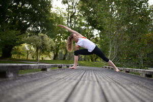Woman doing yoga on bridge