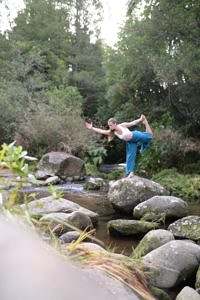 Woman doing yoga on top of rock
